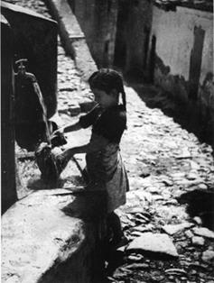 Niña cogiendo agua en una fuente. Pauls (Tarragona). (s.a.). Autor: José Anguera Navarro